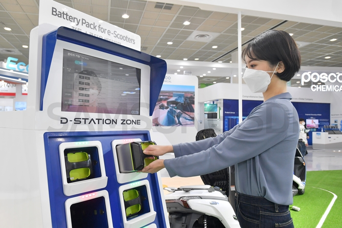 Visitors see and experience how the electric scooter battery pack is charged at the charging station