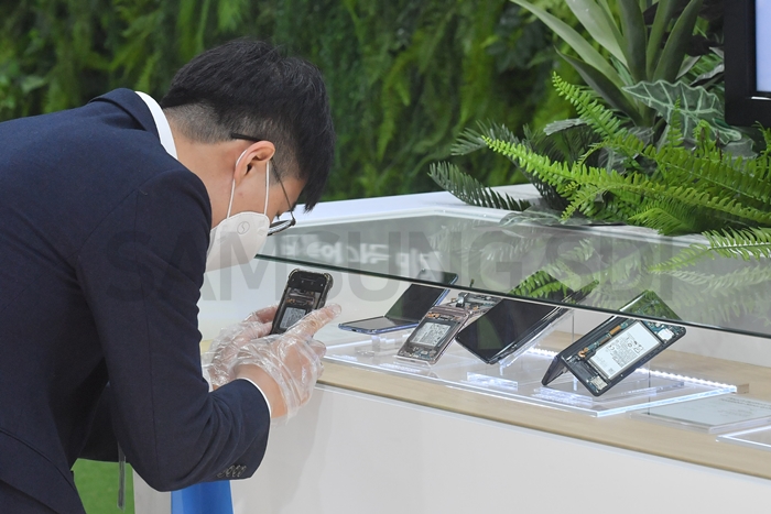 Visitors take a closer look at batteries for foldable phone, smart watch, and wireless earphones at the small-sized battery Zone